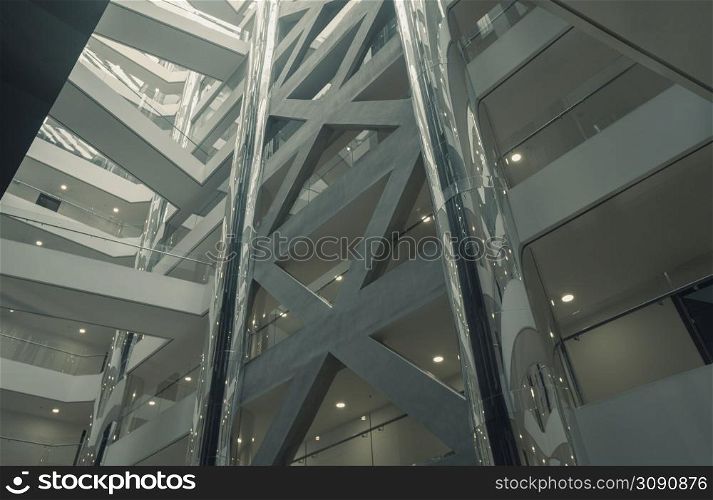 View from below of interior metal and glass structure of an empty modern building without people with light from above. View from below of interior structure in metal and glass of an empty modern building without people