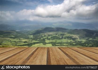 View from Cadair Idris mountain North over countryside landscape. View from Cadair Idris looking North towards Dolgellau over fields and countryside landscape with wooden planks floor