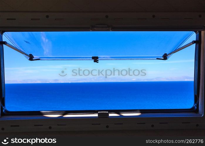 View from camper van window on beautiful calm blue pure sea ocean water.. View from camper window on sea water