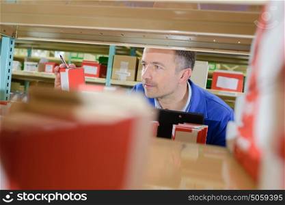 View from shelf of man selecting product