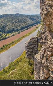 View from the Bastei bridge in the valley of the river Elbe with the typical nature and sandstone rock formations in the hiking area of Saxon Switzerland in Germany. View from the Bastei bridge in the valley of the river Elbe with the typical nature and sandstone rock formations