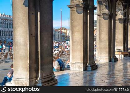 View from the columns of Doge Palace at people, tourists on San Marco square, Vennice, Italy