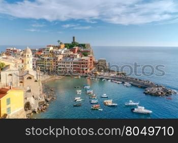 View from the hill of the village of Vernazza and the old harbor on a sunny day. Cinque Terre National Park. Liguria. Italy.. Vernazza. Ancient Italian village on the Mediterranean coast.