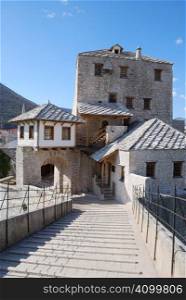 View from the Old Bridge of the west tower and gate in Mostar old town on a sunny day.