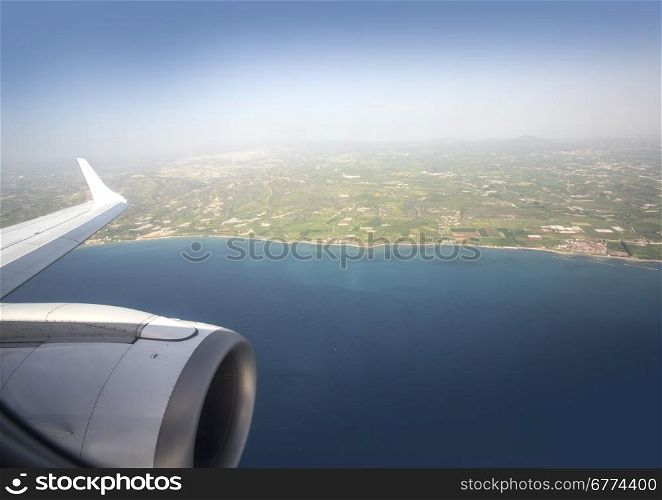 View from the plane on the wing sea and land
