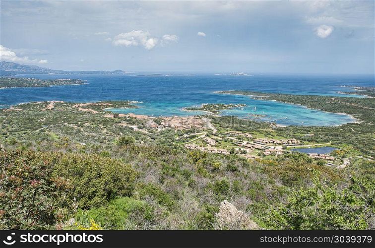 view from the point of the church Santuario Nostra Signora del Monte down to maarinella village with resort and the bay with blue water. view on the skyline of marinella italy. view on the skyline of marinella italy