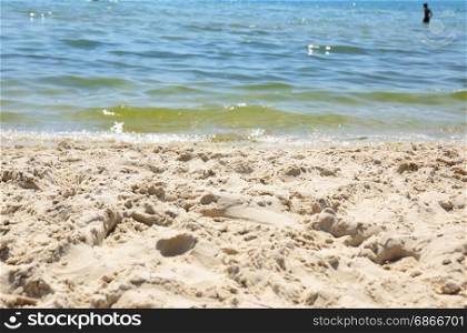 View from the sandy shore to the sea on a summer day, selective focus, bottom view