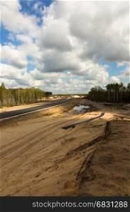 View from the top on highway construction leading through forest.Poland in april.Vertical view.