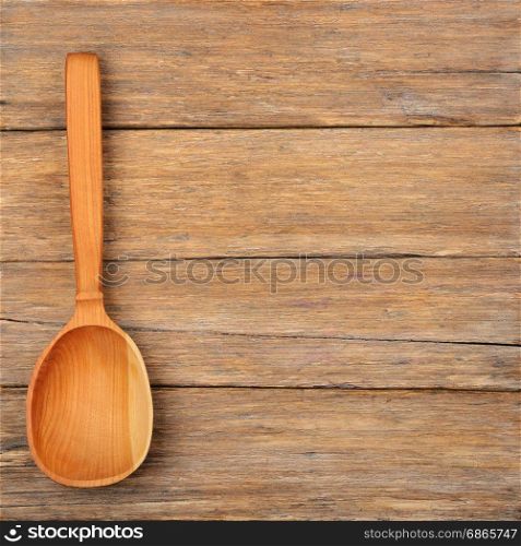 View from top of wooden spoon on wooden table with free space for inscription.
