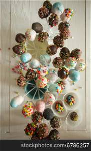 View from top on beautiful colorful cake pops on wooden table at confectionary