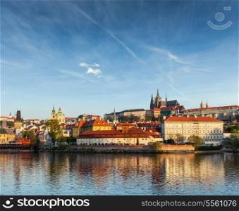 View Gradchany (Prague Castle) and St. Vitus Cathedral over Vltava river on sunset