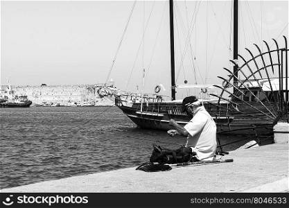 View of a fischerman on the pier of the Rhodes city