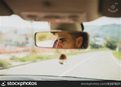 View of a man on the rearview mirror of a car