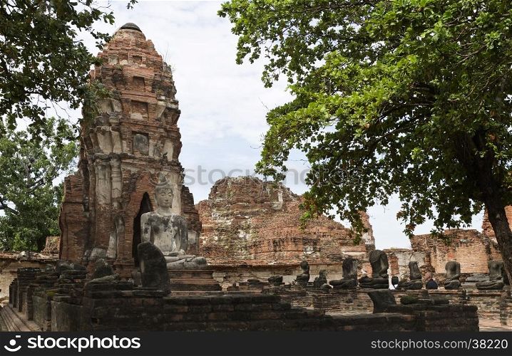 View of a meditating buddha statue sat on a platform in a ruined vihara (hall of worship) at Wat Mahathat, Temple of the Great Relic, a Buddhist temple in Ayutthaya, central Thailand