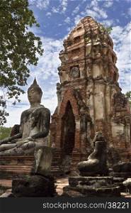 View of a meditating buddha statue sat on a platform in a ruined vihara (hall of worship) at Wat Mahathat, Temple of the Great Relic, a Buddhist temple in Ayutthaya, central Thailand