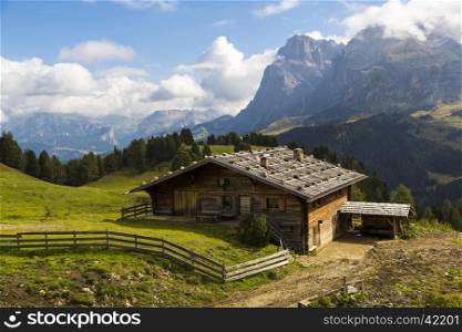 View of a mountain hut on a sunny day with mountains in the background