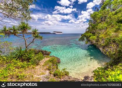 View of a secluded tropical beach with a cruise ship in the background. Symbol of vacation and relaxation