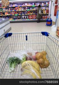 view of a shopping cart with grocery items at supermarket
