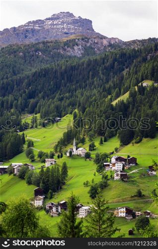 view of a small Italian village located on the slope of the mountains. Dolomites, Italy