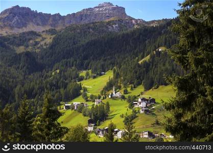 view of a small Typical Italian village located on the slope of the mountains. Dolomites, Italy