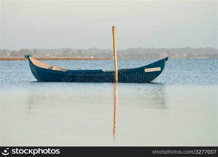 View of a traditional fishing boat anchored on water.