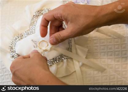 View of a wedding ring placed on a pillow made with glitter heart