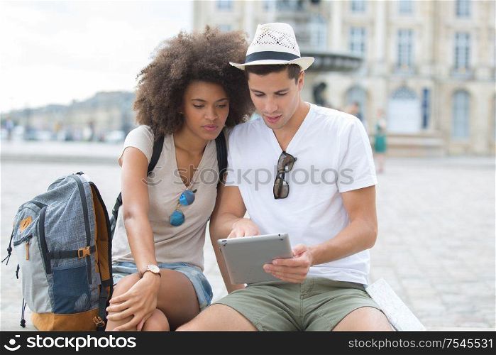 view of a young couple on holidays using a tablet