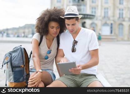 view of a young couple on holidays using a tablet