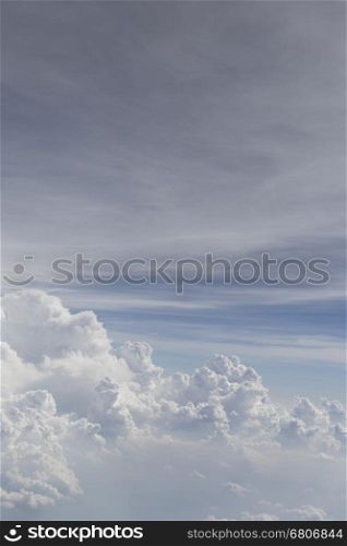 view of airplane wing and cloudscape in blue sky from aircraft window
