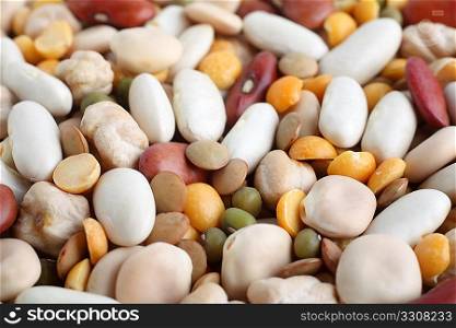 View of an assortment of different dried,pulses from the side, with chickpeas, thermos beans, white beans, red kidney beans, split peas, brown lentils and mung beans