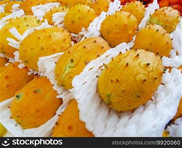 view of an assortment of exotic horned melons on a stand. Selective focus and close up. Exotic fruit concept.