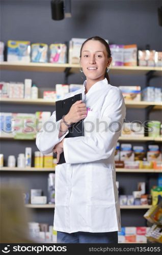 View of an Attractive pharmacist taking notes at work