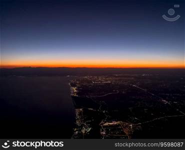 View of Antalya city and city lights from the plane at sunset