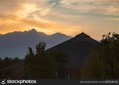 View of Antalya Glass Pyramid Exhibition and Congress Center at sunset with mountains in the background