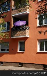 View of apartment block with purple umbrella on balcony