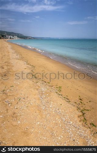 View of beautiful beach, blue sky and resort. Summer beach vacation / Sea waves on sand beach water and coast seascape