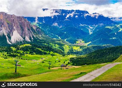 View of beautiful mountain of Dolomites and the village in the valley in summer sunny day at Secada Peak in South Tyrol Italy
