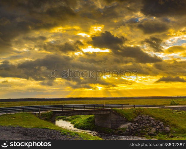 View of beautiful sunset at a bridge and a stream in Iceland