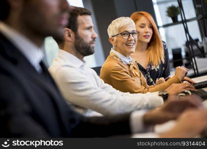 View of businessman executive in group meeting with other businessmen and businesswomen in modern office with computer