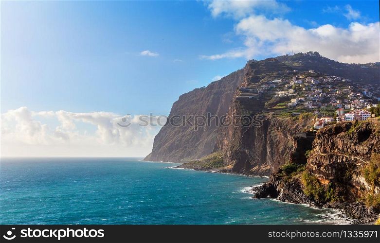 View of Cabo Girao cliff and Camara de Lobos town tropical agave plants in foreground, Madeira island, Portugal