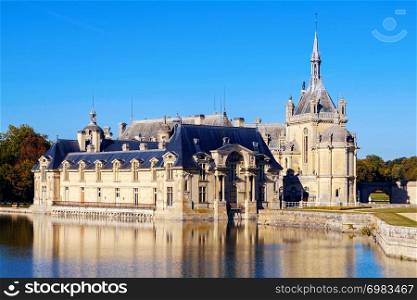 View of Chantilly castle with reflection in water, France. Chantilly castle museum