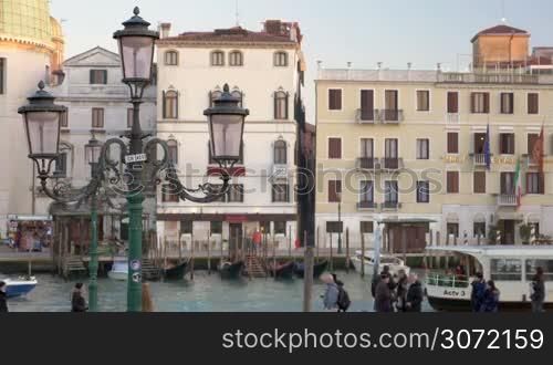 View of city. Old style houses, boats sailing along the canal and people walking. Vintage lantern in foreground