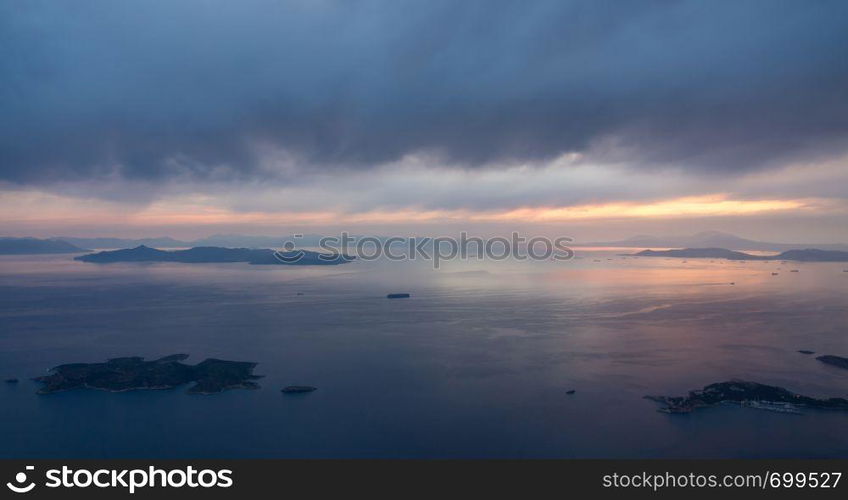 View of coastline and islands near Athens airport as plane descends at sunset. Aerial view of the descent into Athens Airport in Greece