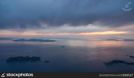 View of coastline and islands near Athens airport as plane descends at sunset. Aerial view of the descent into Athens Airport in Greece