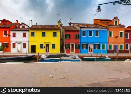 View of colorful houses along the canal on the island of Burano. Burano. Italy. Venice.. Facades of traditional old houses on the island of Burano.