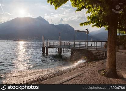 View of Como lake on sunset with pier in Bellagio, Italy
