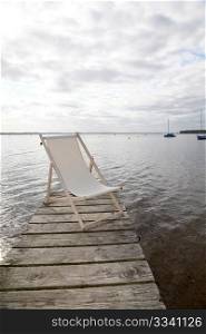 View of deck chairs set on a lake pontoon