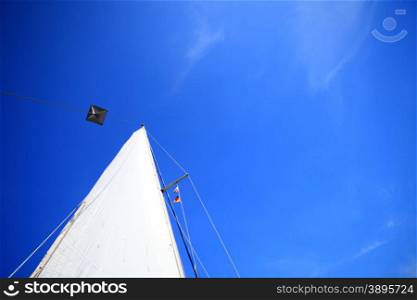 view of different parts of yacht. White sail of a sailing boat over blue clear sky