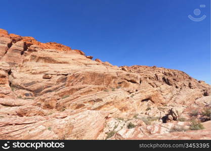 View of dry landscape and red rock formations of the Red Rock Canyon in the Mojave Desert.