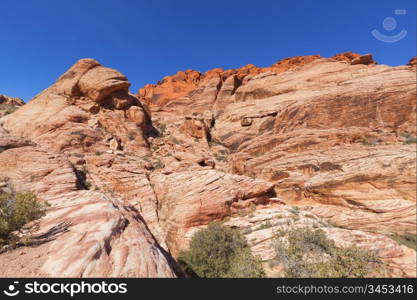 View of dry landscape and red rock formations of the Red Rock Canyon in the Mojave Desert.